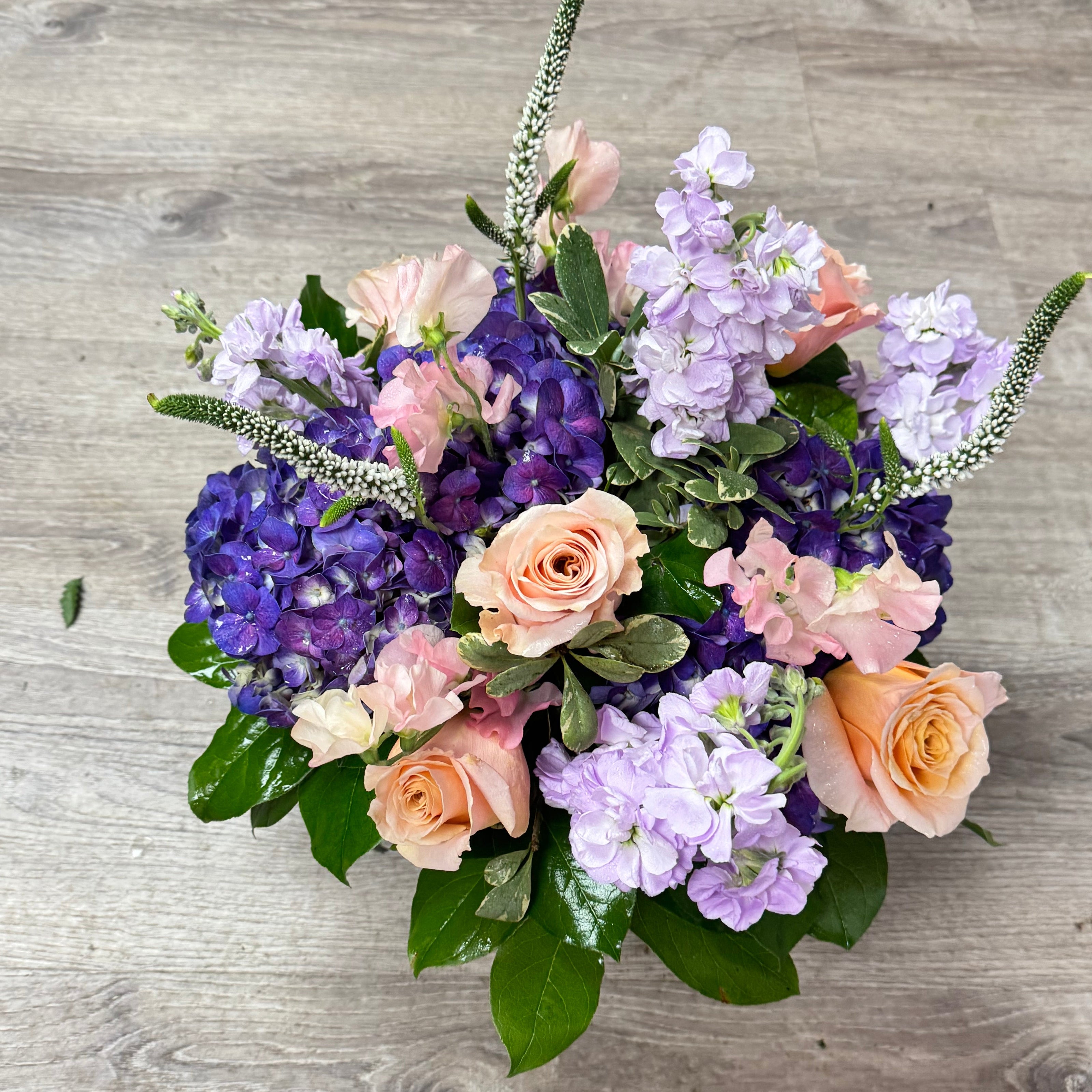 Bouquet of flowers with purple and pink flowers on a wooden surface